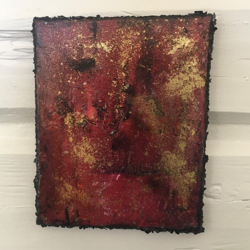 Rektangulært kunstverk, 20×15 cm, med abstrakt ansikt i rødt og gull med grov sort teksturert kant. Tre ansikter, akryl og mixmedia. Art by Emerense