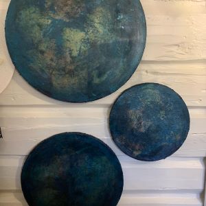 Tre runde malerier i størrelsene 20, 30 og 40 cm diameter, hengt på hvit trepanel. Dype blå og turkise nyanser med metallisk tekstur. 3 univers, akryl og metall. Art by Emerense