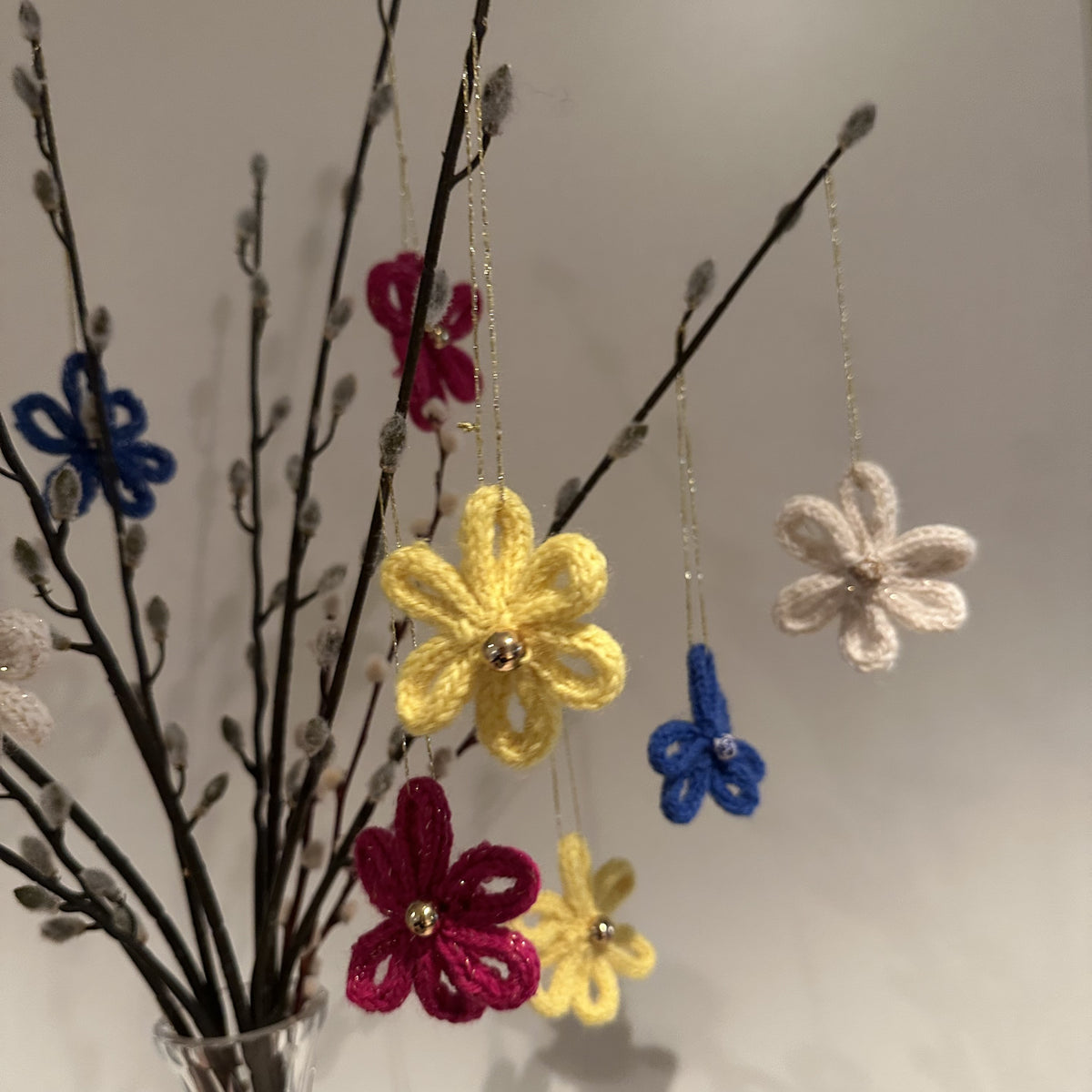 Venneblomster fra Emerense – håndlagde blomster av strikkede snorer med perle og gulltråd til oppheng