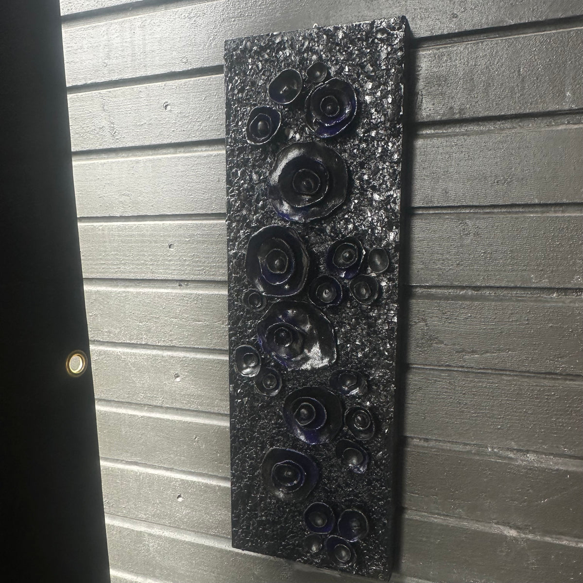 Originalt kunstverk Rosehage Mørk Blå hengt på grå vegg – tredimensjonale mørke roser i mix medium. Art by Emerense