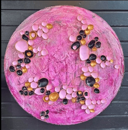 Rundt kunstverk ca. 40 cm med tredimensjonale rosa, sorte og gyldne halvkuler på teksturert rosa lerret. Pink Fantasy av Art by Emerense