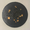 Rundt kunstverk, 30 cm, med sorte og gyldne tredimensjonale former på mattsvart teksturert lerret. Velsignelse av Art by Emerense