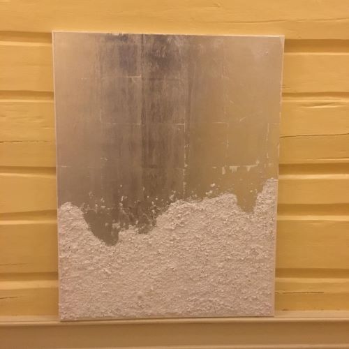 Rektangulært akrylmaleri, 50×70 cm, hengt på gul trepanel. Abstrakt fjelllandskap i hvitt og grått med strukturert snøaktig overflate. Fjellheimen av Art by Emerens