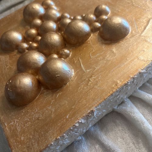 Nærbilde av krakelert gulloverflate med tredimensjonale halvkuler – detalj av Sprukket boble eleganse. Art by Emerense